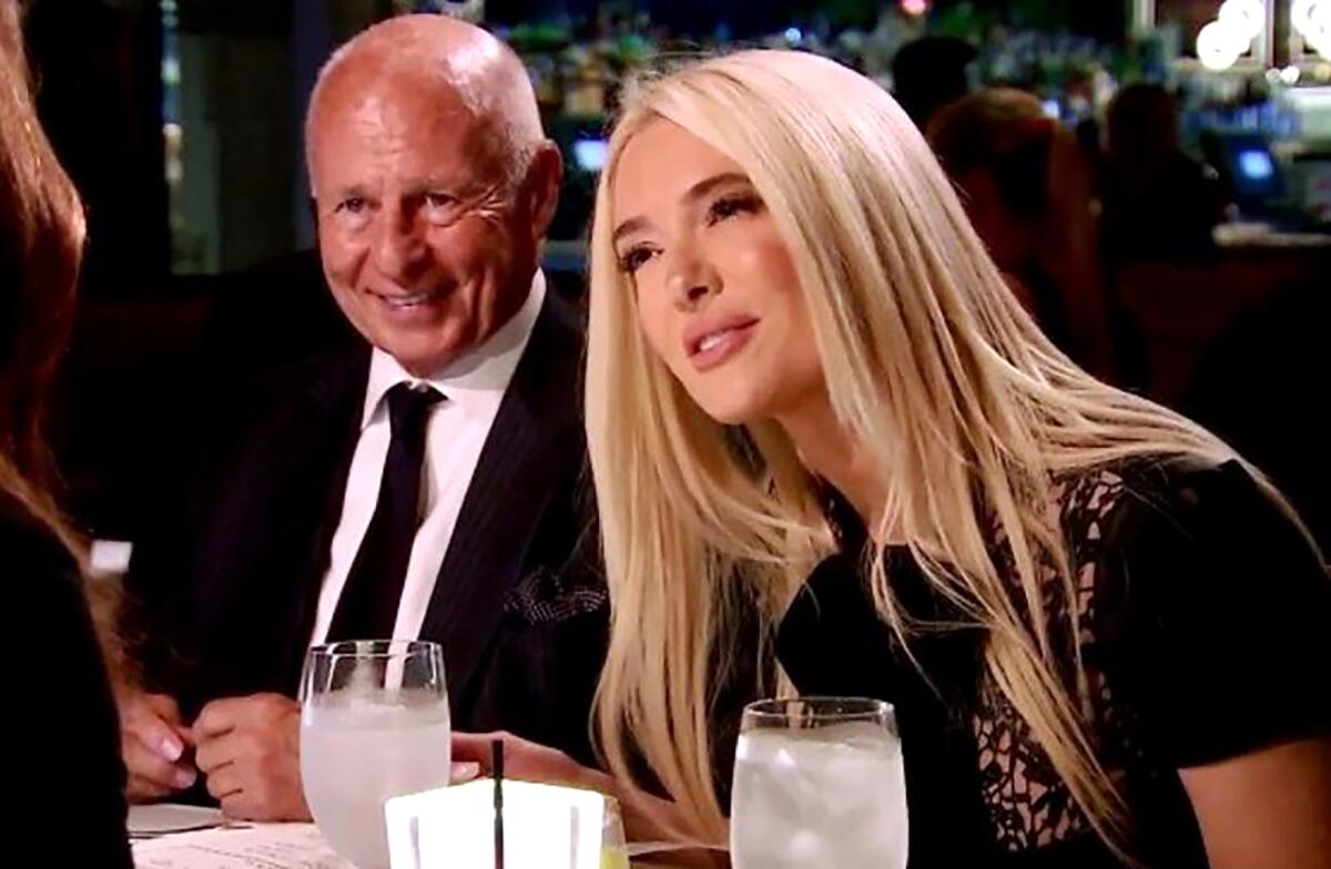 A well dressed man and woman at a dinner table.