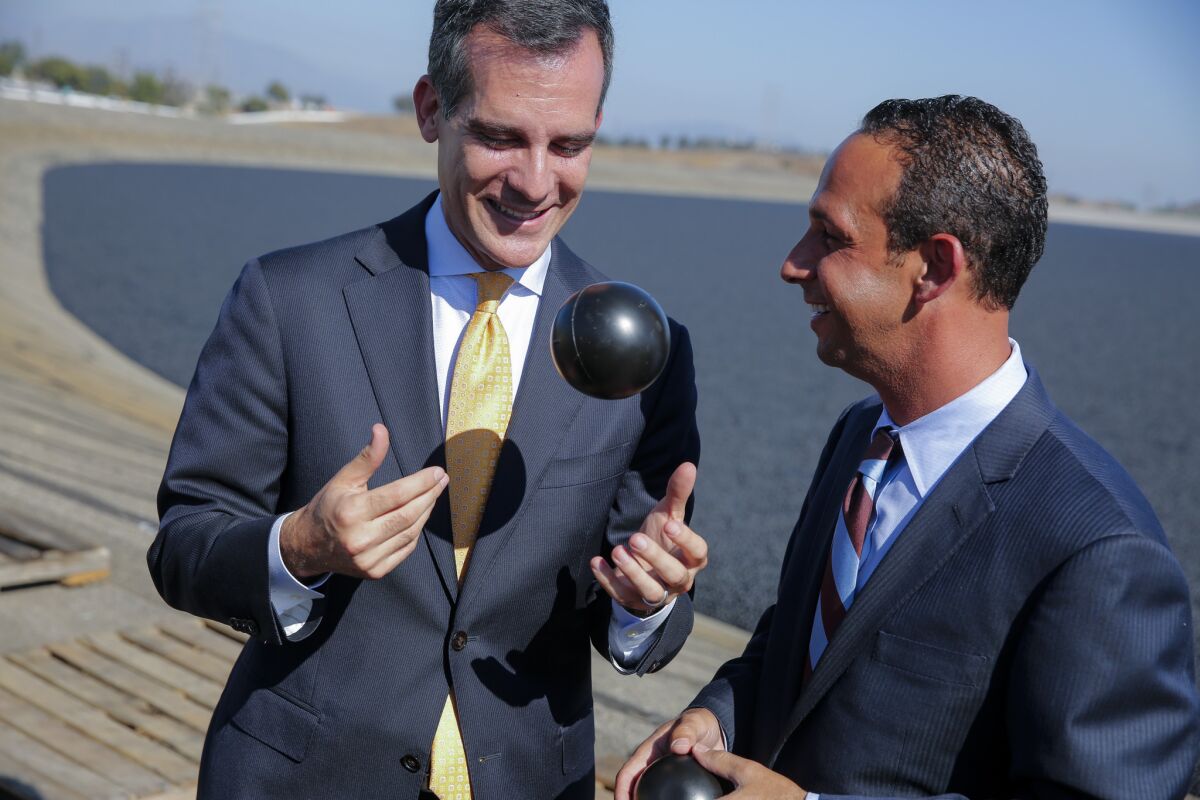While Mayor Eric Garcetti, left, with Councilman Mitchell Englander, touted the city’s release of 20,000 small black balls into the Los Angeles Reservoir as "bold ingenuity."