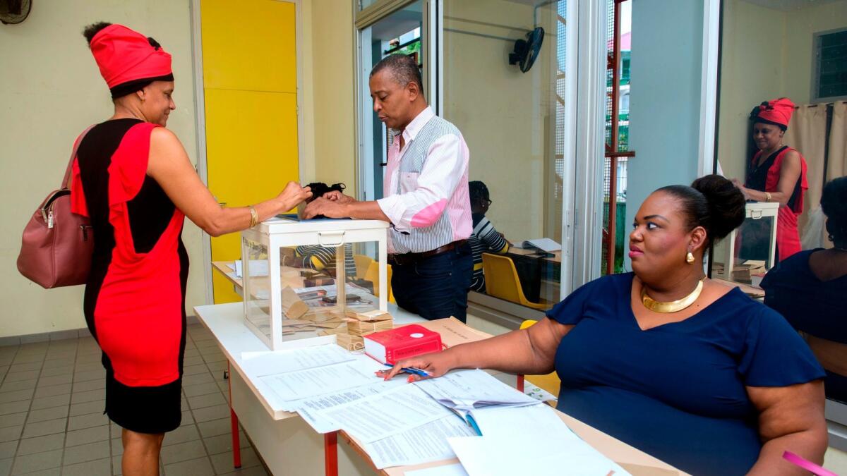 A woman casts her ballot during the second round of the French presidential election at a polling station on the French territory of Guadeloupe.