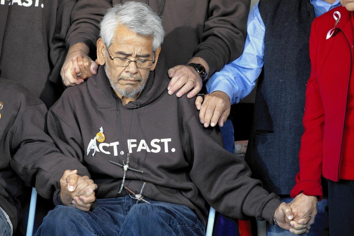 Eliseo Medina holds hands during a prayer at an event ending his 2013 fast after 22 days. He is heading to Washington, D.C., to lead another protest for immigration reform.