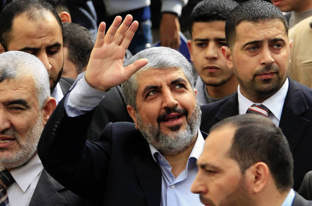 Exiled Hamas leader Khaled Meshaal waves to Palestinian students during his visit to the Islamic University in Gaza City on Dec. 9