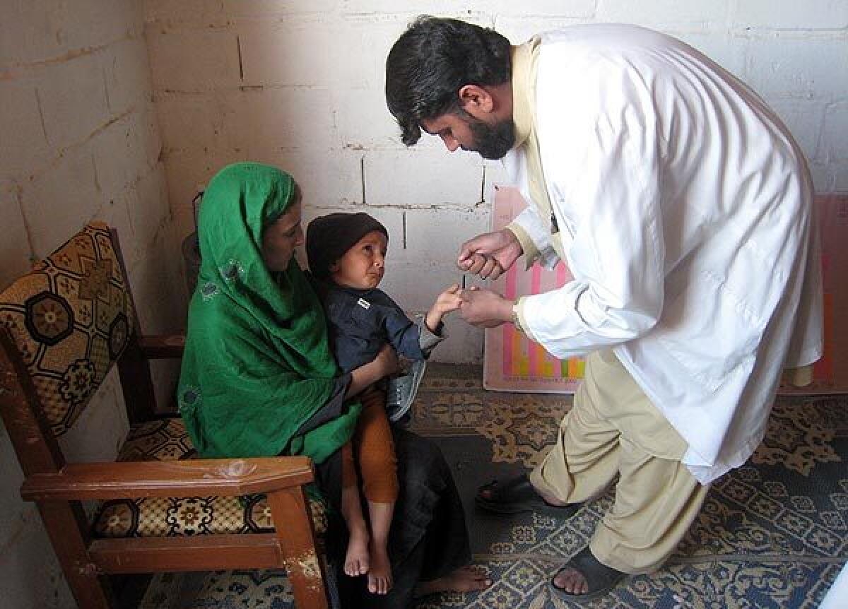 Lab technician Nasratullah Ahmadzai takes a blood sample at the International Medical Corps health center at Lower Sheikh Mesri camp for returning refugees near Jalalabad, Afghanistan. The corps, a Los Angeles-based nonprofit, trains health workers in remote and dangerous areas.