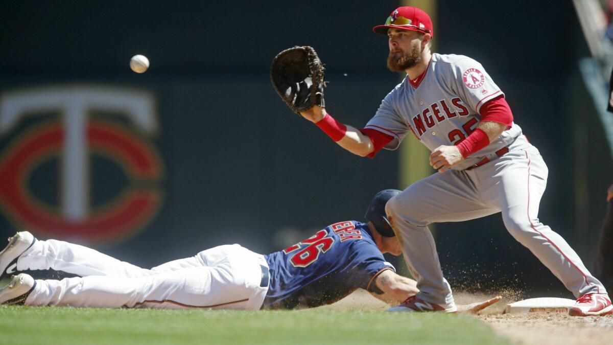 Minnesota's Max Kepler dives back to first base as Angels rookie Jared Walsh awaits the ball May 15 in Minneapolis.