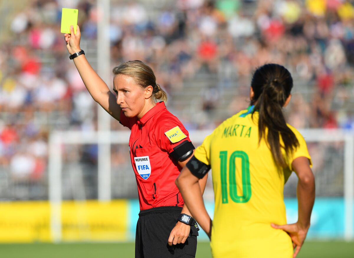 Referee Katja Koroleva issues a yellow card to Brazil's Raquel (not pictured) as teammate Marta reacts against Japan during the second half of a Tournament of Nations game played at Pratt & Whitney Stadium on July 29, 2018 in East Hartford, Conn.