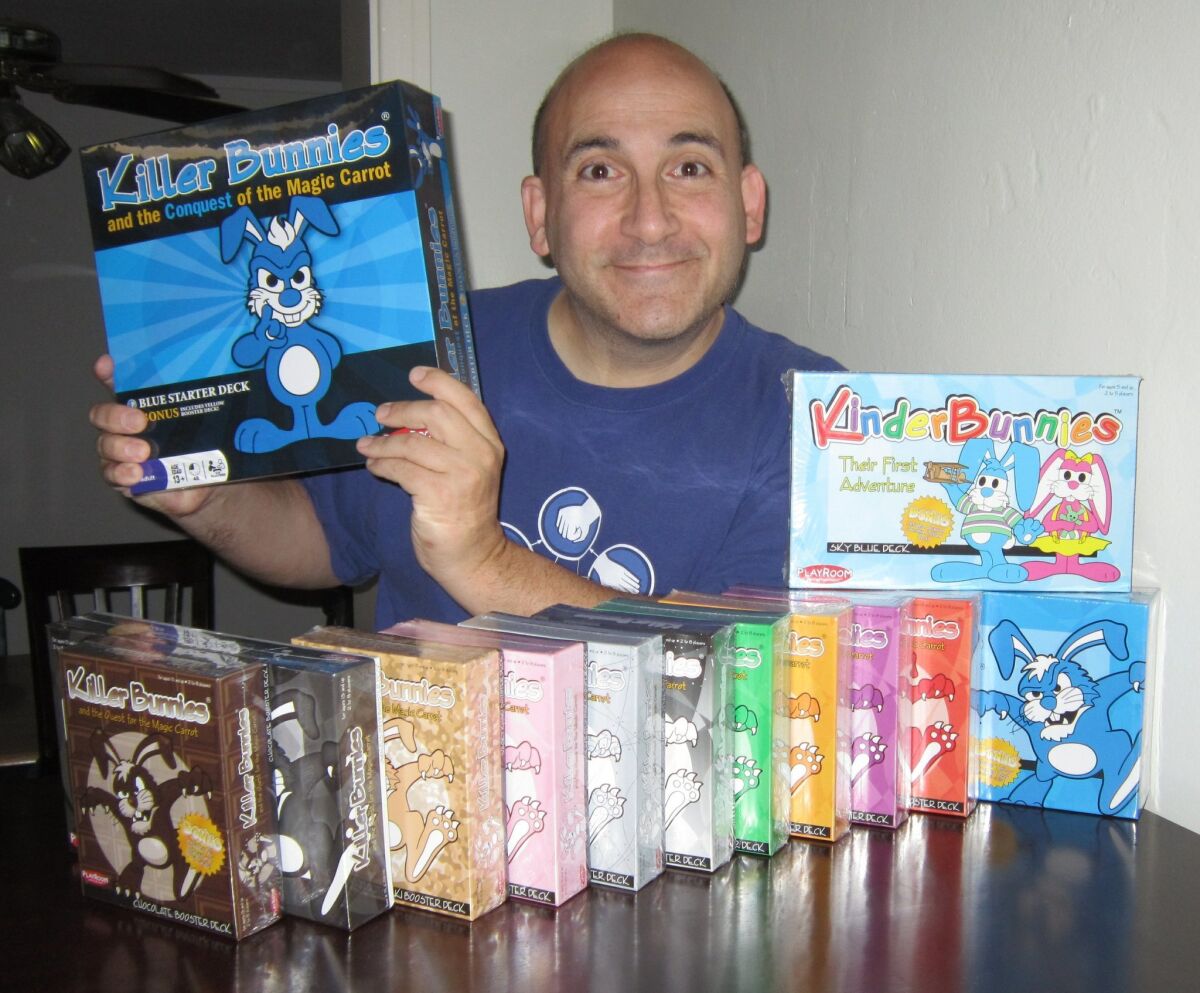 Jeffrey Bellinger poses with some of the Killer Bunnies games he created.