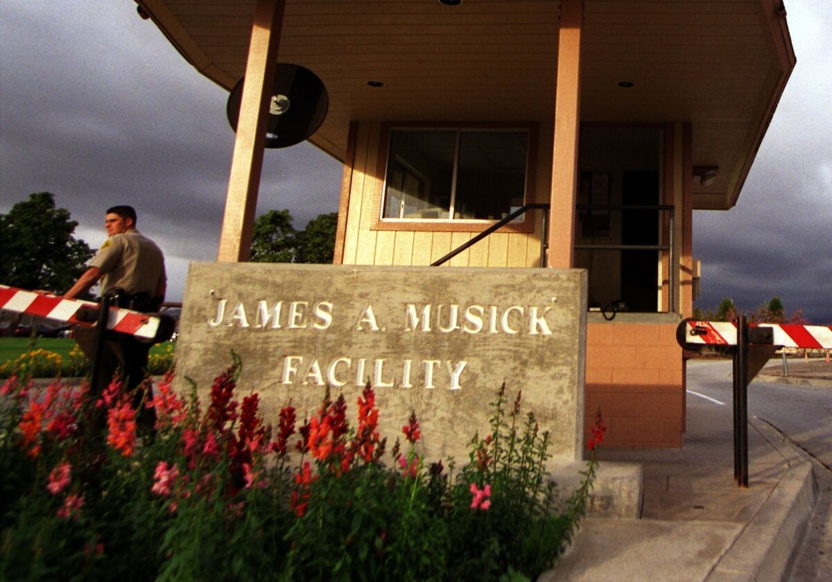 A guard stands at the front gate of the James A. Musick Facility in Irvine.