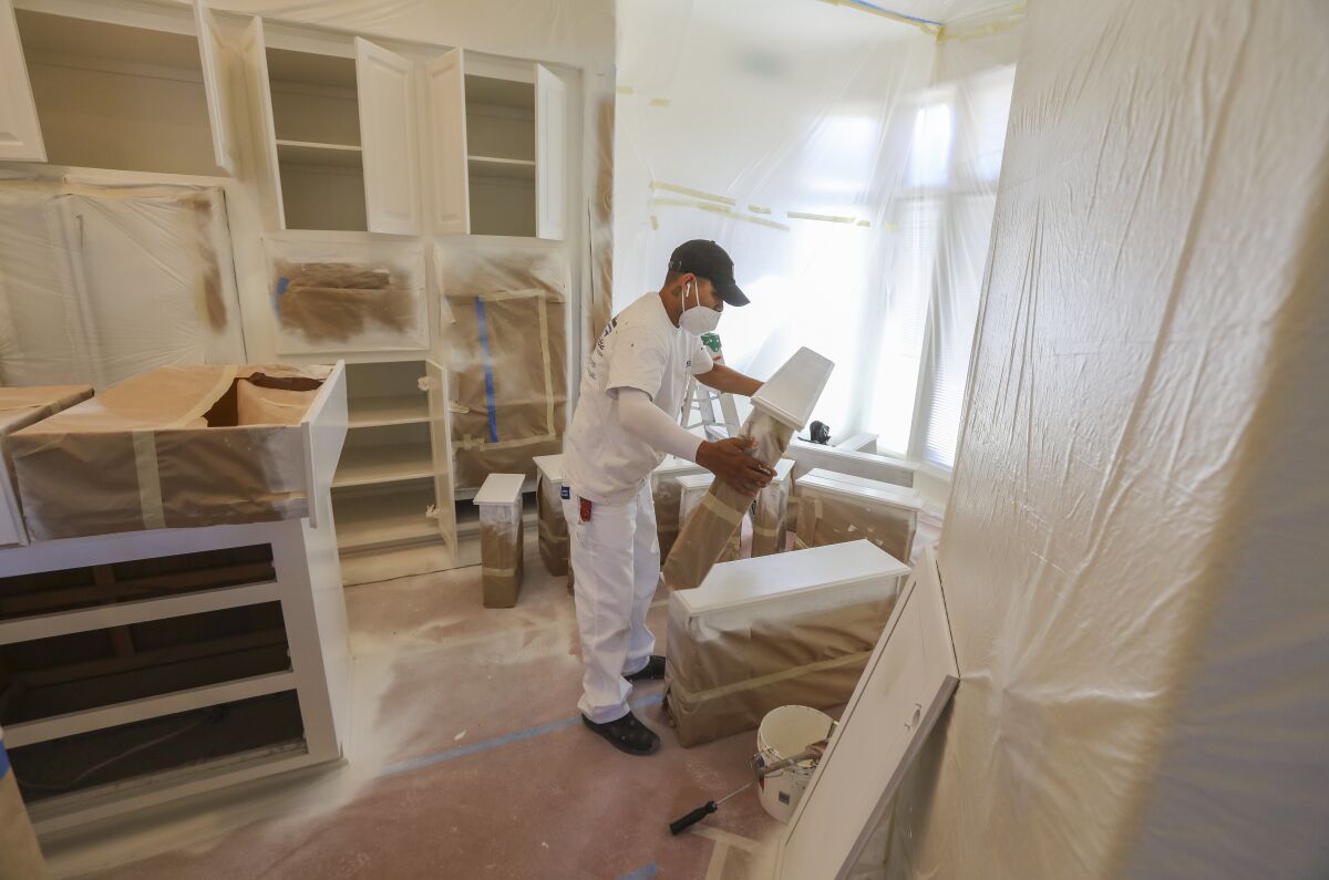 Christian Benitez of San Diego City Painting, works in the kitchen painting cabinets at a La Jolla home on July 16, 2020.