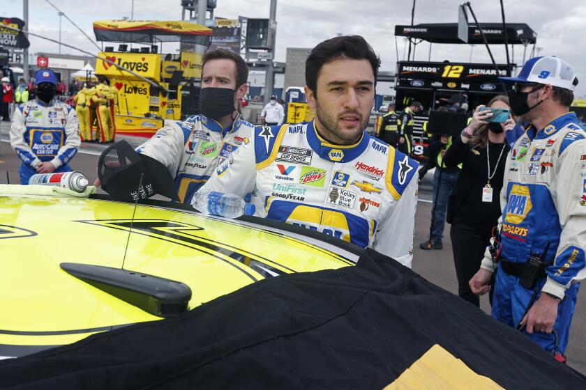 Chase Elliott climbs into his race car on pit road prior to the NASCAR Cup Series auto race at Phoenix Raceway, Sunday, Nov. 8, 2020, in Avondale, Ariz. (AP Photo/Ralph Freso)