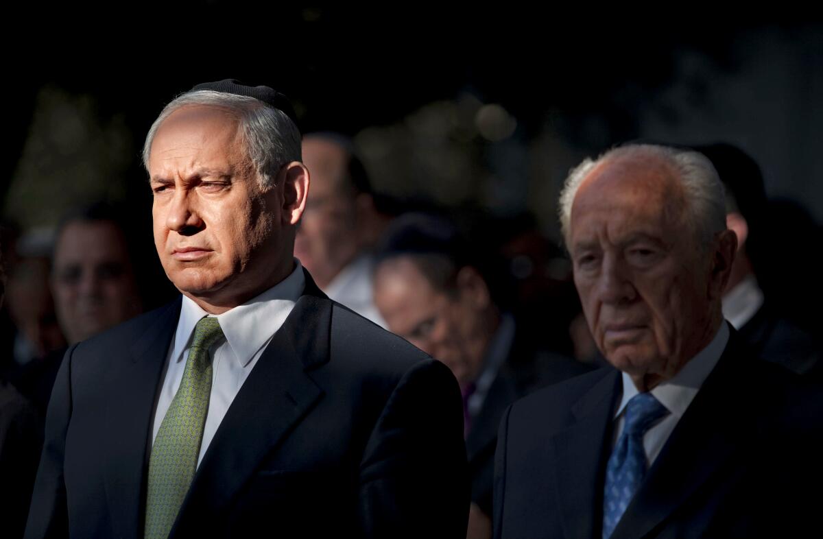 Benjamin Netanyahu stands next to Shimon Peres. 