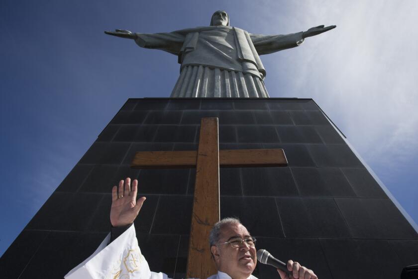 In this July 12, 2013, file photo, Archbishop Orani Joao Tempesta of Rio de Janeiro is among 19 new cardinals named by Pope Francis on Sunday. Above, Tempesta gives a sermon last summer in front of the World Youth Day cross and the Christ Redeemer statue in Rio.
