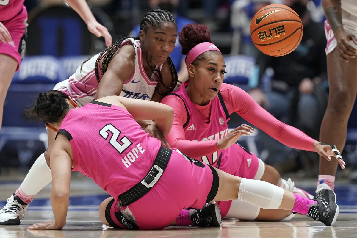 North Carolina State guard Raina Perez (2) and forward Jakia Brown-Turner (11) struggle for the ball with Duke guard Shayeann Day-Wilson during the second half of an NCAA college basketball game in Durham, N.C., Sunday, Feb. 13, 2022. (AP Photo/Gerry Broome)