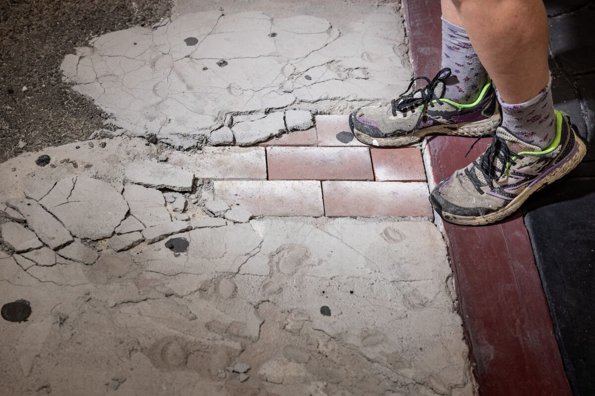 The working shoes of artist Fiona Connor, photographed next to a portion of her "Continuous Sidewalk."