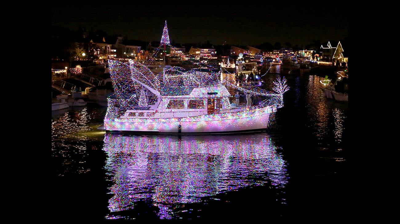 One of the first boats in the annual Huntington Harbour Boat Parade in Huntington Beach on Saturday was decorated with a canopy of lights. The theme for this year was "Space Odyssey."