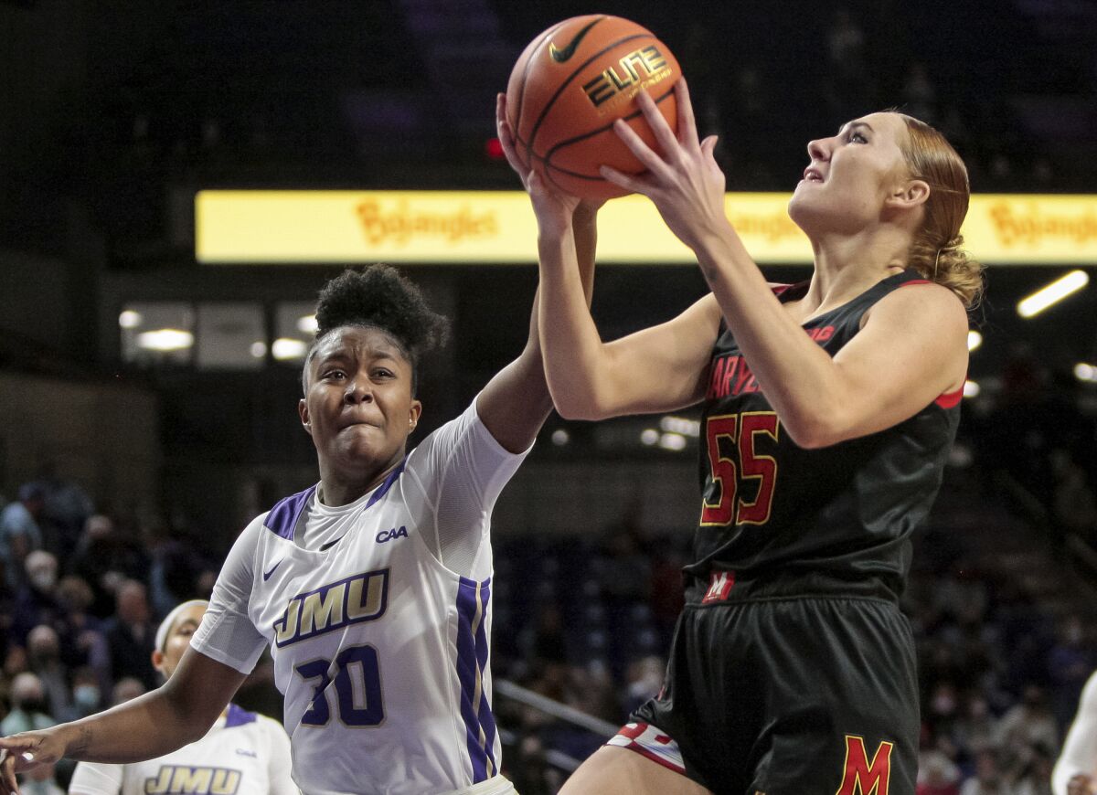 Maryland forward Chloe Bibby (55) goes up to shoot under pressure from James Madison guard Kiki Jefferson (30) during the first half of an NCAA college basketball game in Harrisonburg, Va., Sunday, Nov. 14, 2021. (Daniel Lin/Daily News-Record Via AP)