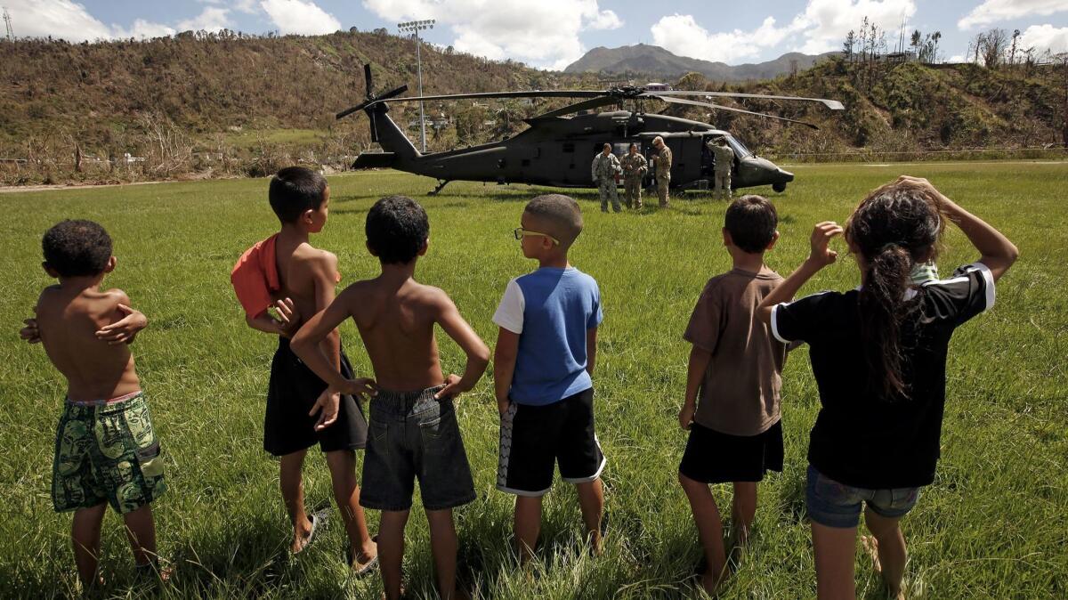 In the mountain town of Juyaya, Puerto Rico, children watch as a U.S. Army helicopter transports a team of medical doctors who have come to assess the medical needs of the local hospital and residents. the medical needs of the local hospital and residents.