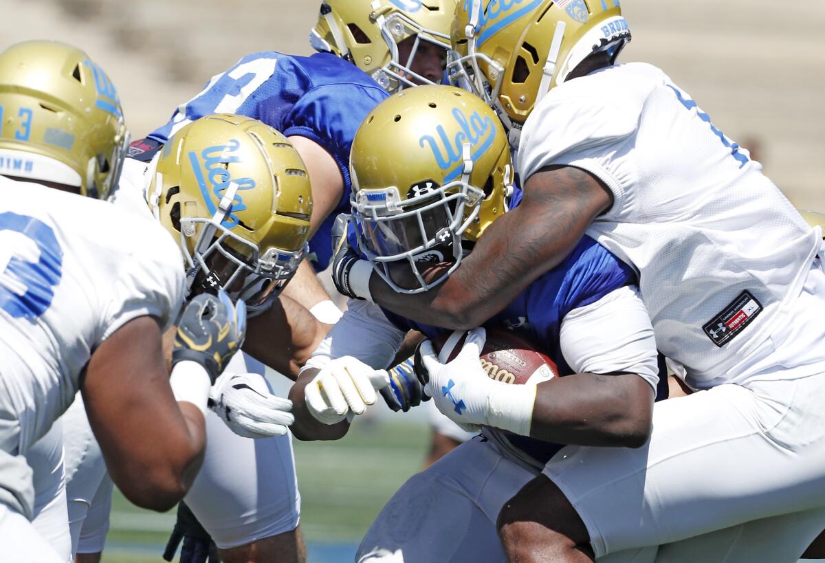 UCLA running back Bolu Olorunfunmi is brought down during the Bruins' spring football game at Drake Stadium on April 21.