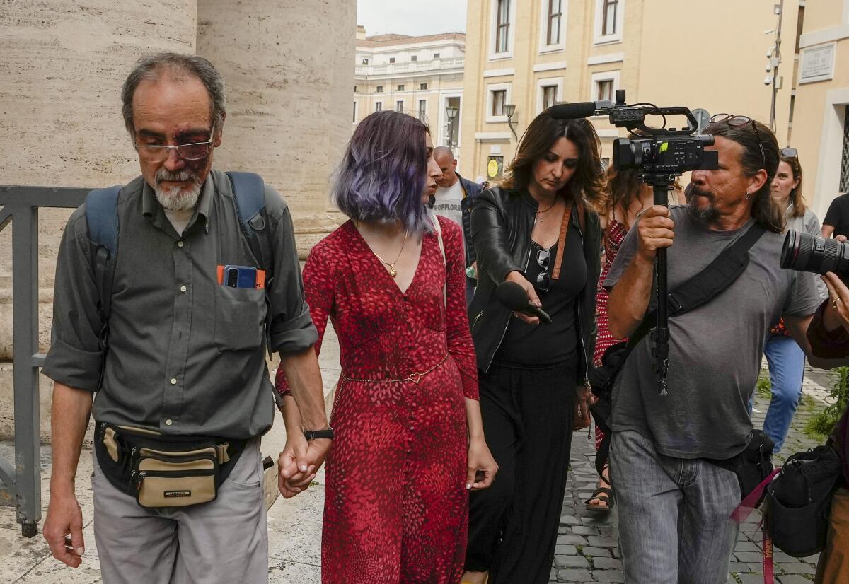 Activists Guido Viero, left, and Ester Goffi hold hands as they arrive at the Vatican on May 24 for their trial 