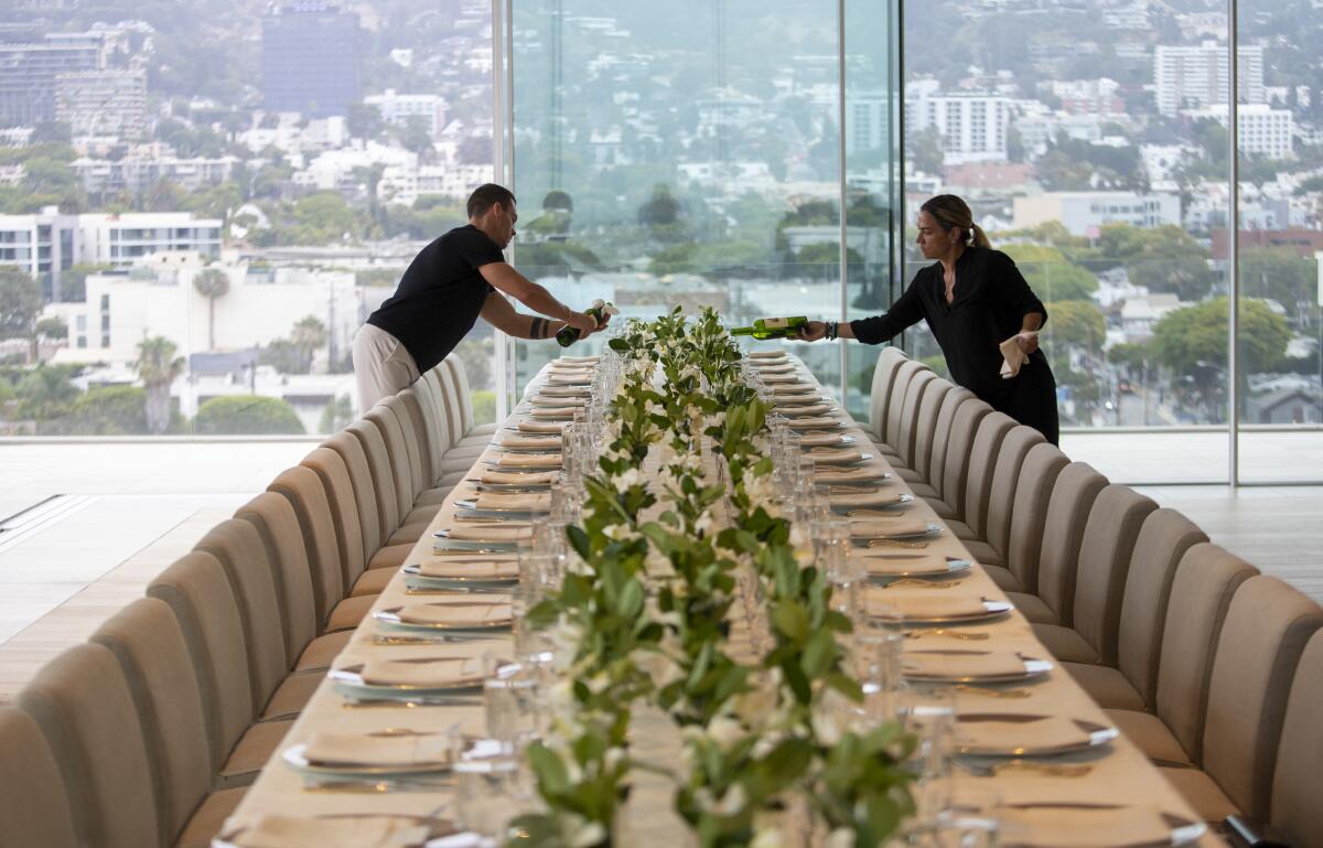 Wine is poured as staff prepares a five-course dinner during a VIP event at 8899 Beverly.