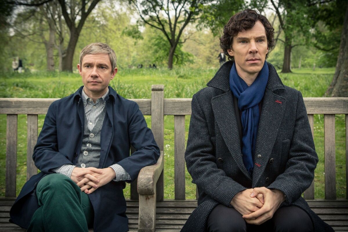 Martin Freeman, left, as Dr. Watson, and Benedict Cumberbatch, as Holmes, sitting on a bench in "Sherlock."