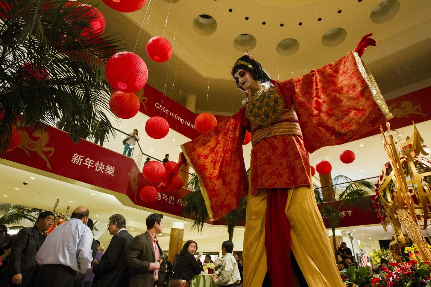 Seraphina Whitman with Stilt Circus entertains the crowd during the South Coast Plaza's celebration of the Year of the Horse during the opening ceremony of a three week Lunar New Year celebration on Thursday.