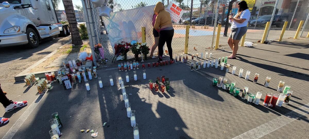 Friends leave flowers and candles at a memorial in Compton.