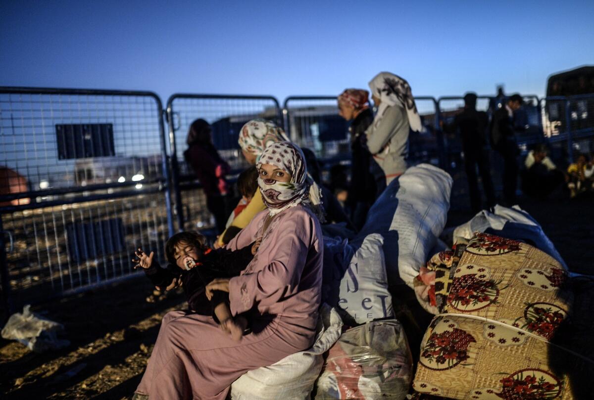 Syrian Kurds wait at a Turkish police checkpoint near the Syrian border town of Suruc on Sept. 21.