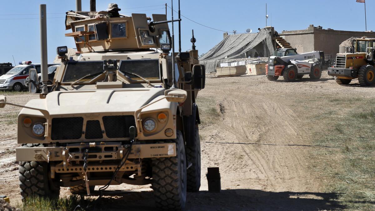 A U.S. soldier sits on an armored vehicle at a position in Manbij, Syria, in April.