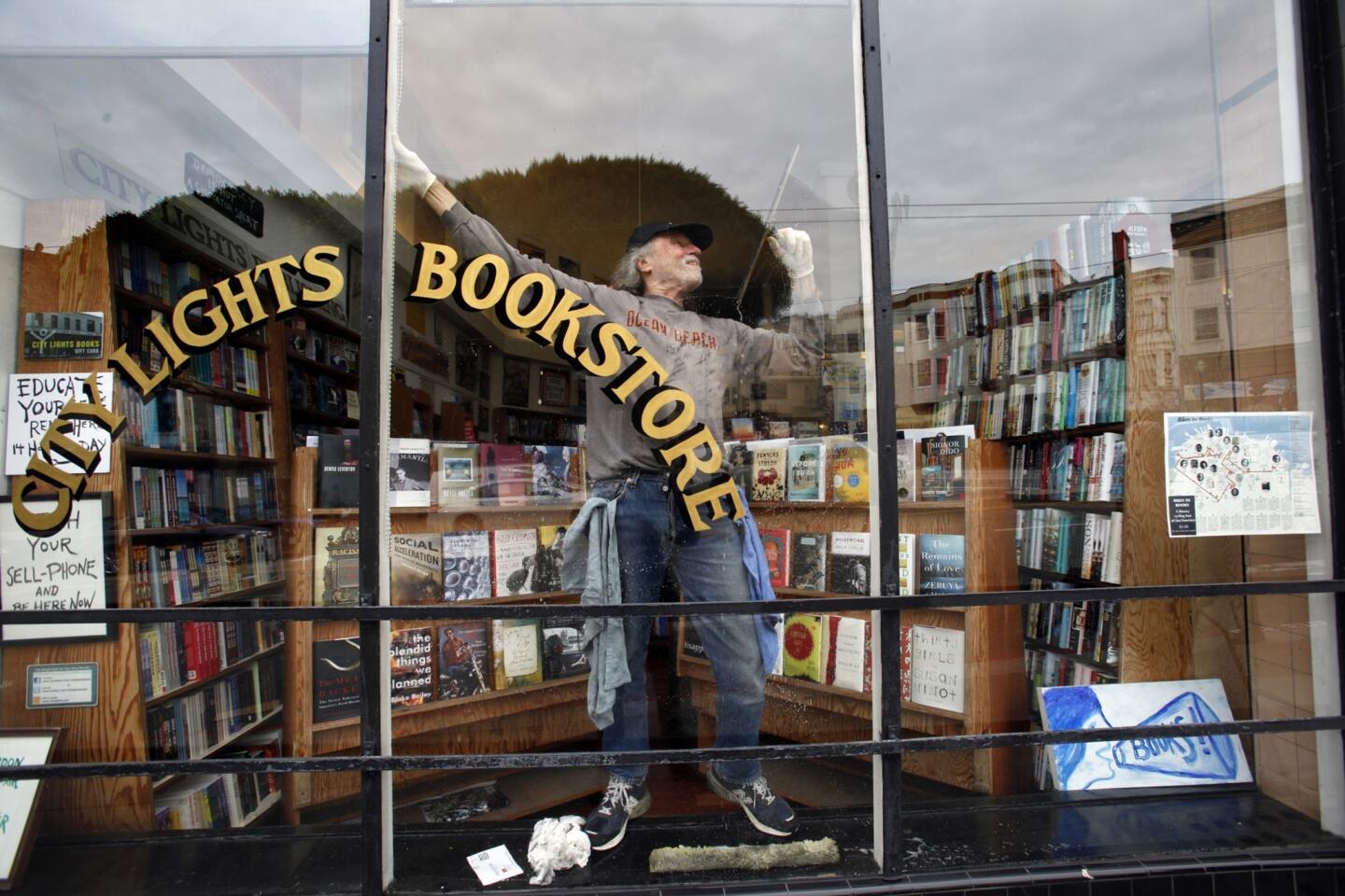 Hanging on to the window sill, Peter Munk does a delicate ballet while washing windows at City Lights. Munk, who has been washing the bookstore's windows since 1974, does a thorough washing once a month and takes extra time to clean the mosaic design at the front door entryway.