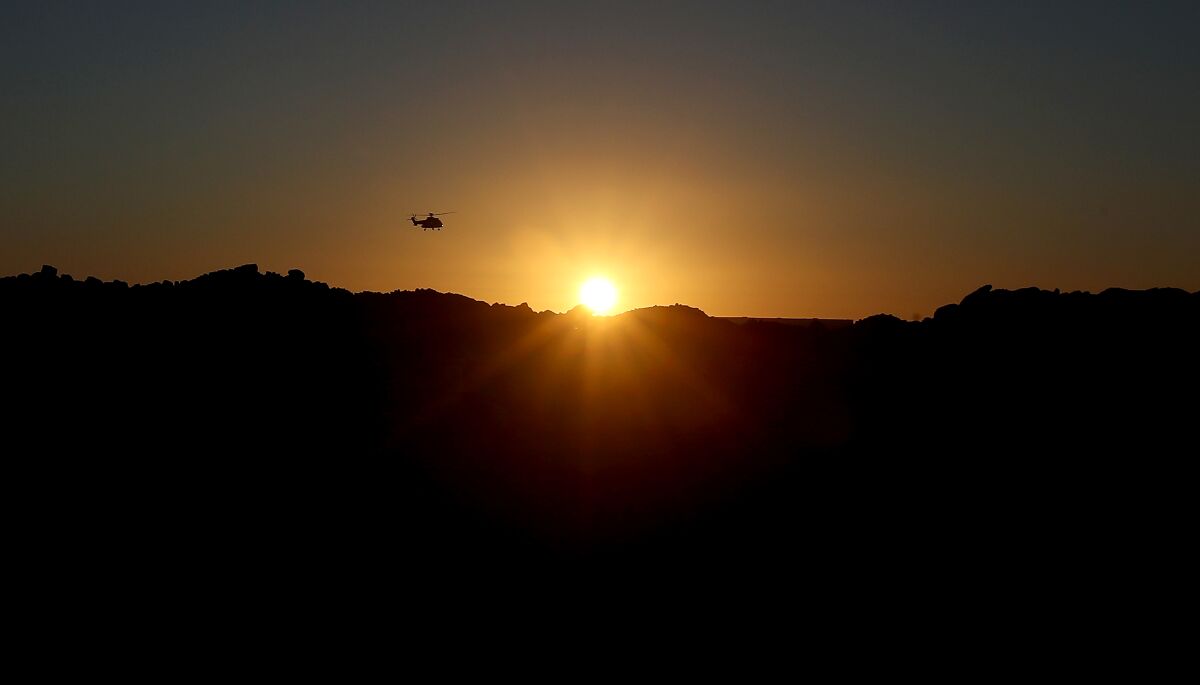 A helicopter approaches Long Beach Airport as the sun sets.