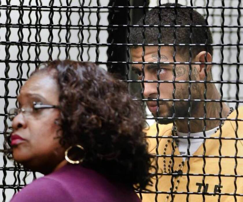 Human-trafficking suspect Curtis Maurice Canady, 19, right, and his lawyer, Public Defender Diane Herring, listen to the judge in Orange County Superior Court.