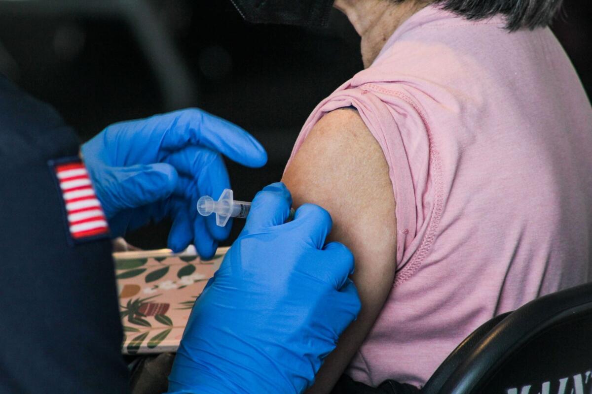 A woman receives a COVID-19 vaccine shot at the Disneyland lot in Anaheim.