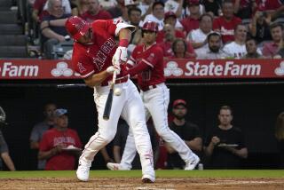 Los Angeles Angels' Mike Trout, left, grounds into a double play as Shohei Ohtani watches during the third inning of a baseball game against the Cincinnati Reds Tuesday, Aug. 22, 2023, in Anaheim, Calif. (AP Photo/Mark J. Terrill)