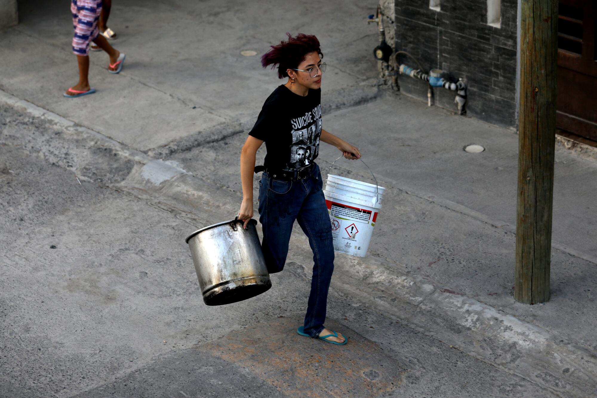  A woman runs with two buckets