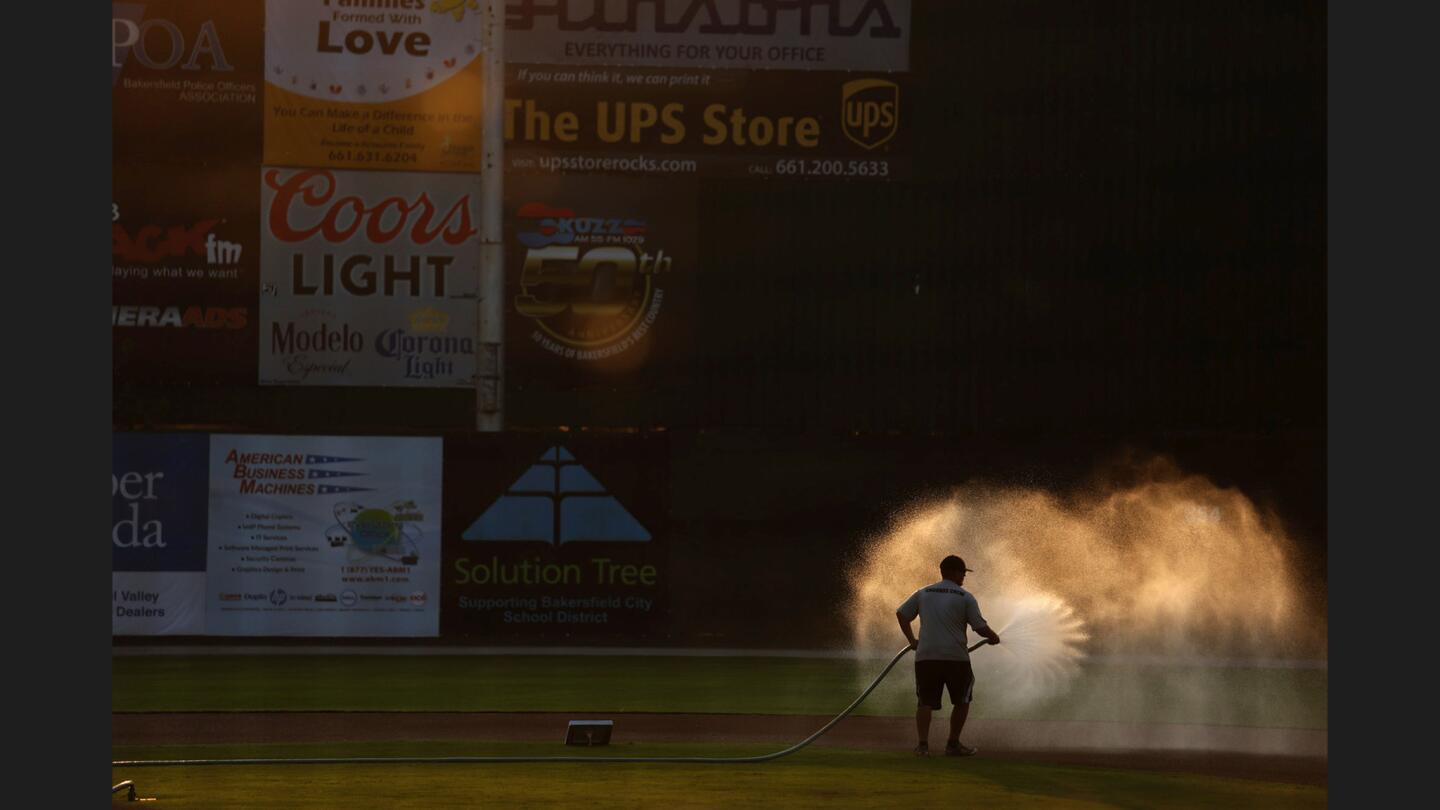 A groundskeeper waters down the field in the late afternoon light before the Blaze play one of their last games at Sam Lynn Ballpark.