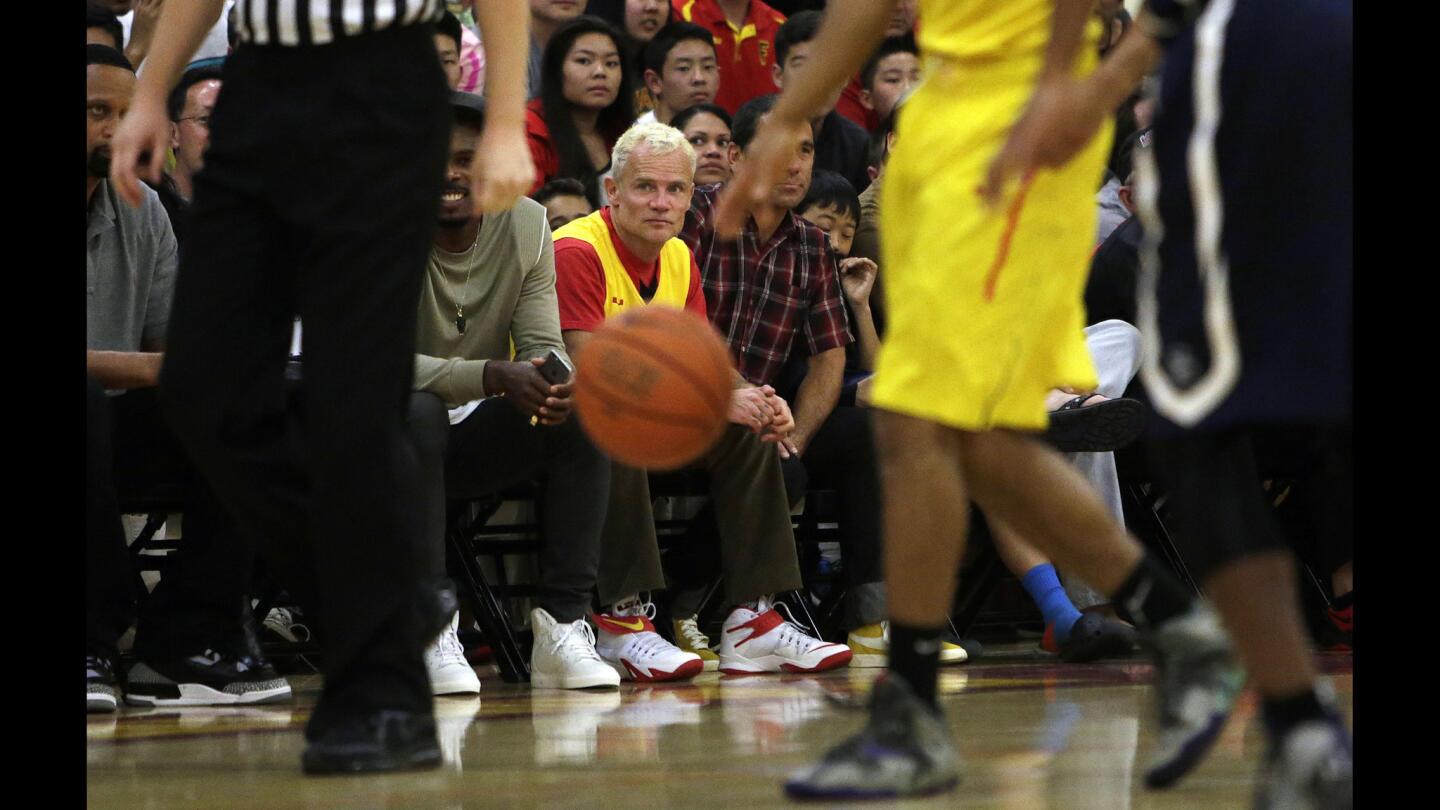 Flea, the bassist for the Red Hot Chili Peppers (yellow shirt), sits court side during the game between Sierra Canyon and Fairfax at Fairfax High School.