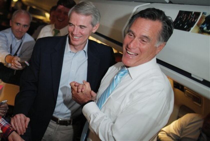 Republican presidential candidate and former Massachusetts Gov. Mitt Romney and Sen. Rob Portman, R-Ohio, talk to reporters on board the campaign charter plane as it flies to Bedford, Mass., Friday, Sept. 14, 2012. (AP Photo/Charles Dharapak)