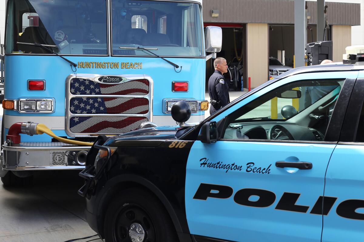 A police vehicle and fire truck are wrapped blue in support of Prostate Cancer Awareness Month.