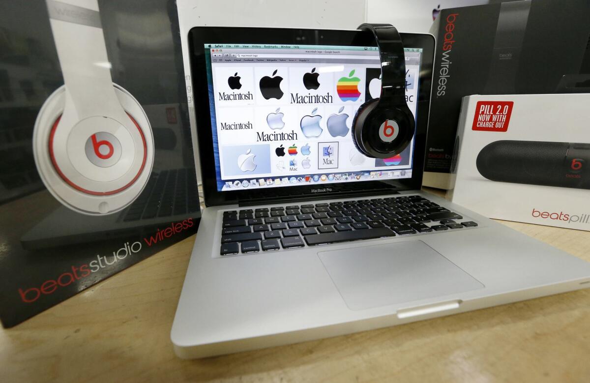 Beats Audio equipment is arranged for a photo next to an Apple laptop at Best Buy in Boston on Friday. Apple reportedly is orchestrating a $3.2 billion acquisition of Beats Electronics, the headphone maker and music streaming distributor.
