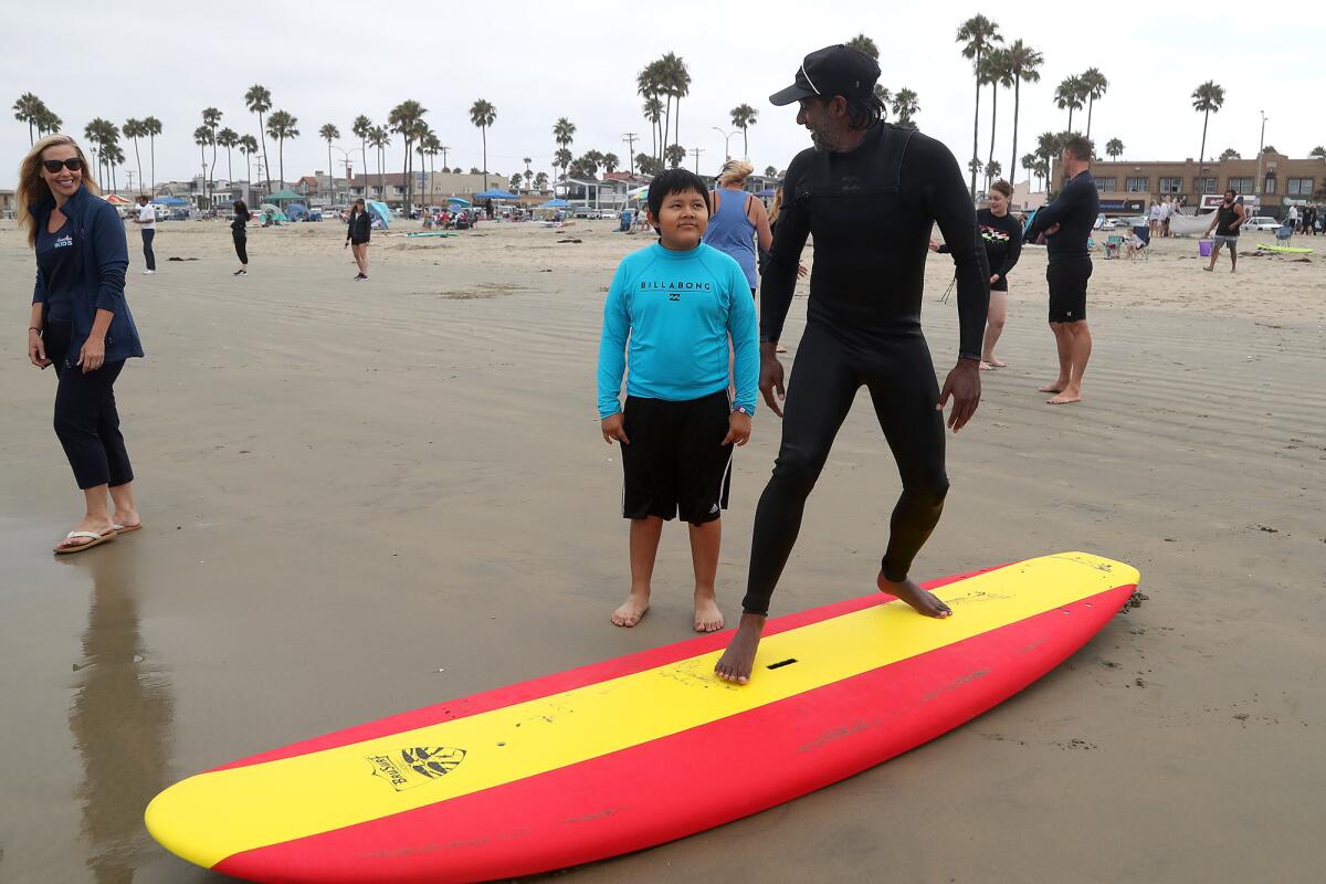 Francisco Paxtor, 10, listens as Ajai Datta with Boardriders gives surfing tips.