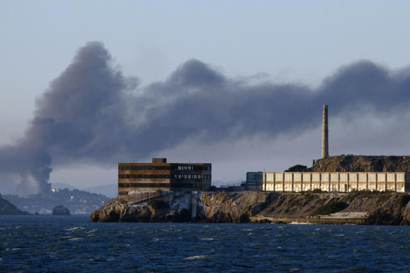 Smoke from a fire at the Chevron Richmond Refinery drifts over San Francisco Bay in august 2012. In the foreground, Alcatraz.