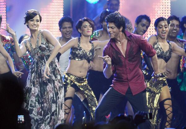 Indian actor Shah Rukh Khan, right, and actress Dia Mirza, left, dance.