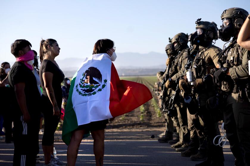Camarillo, CA - July 10: Protestors confront federal agents who form a line during an immigration raid at the Glass House on Laguna Road on Thursday, July 10, 2025, Camarillo, CA. Julie Leopo / For The Times