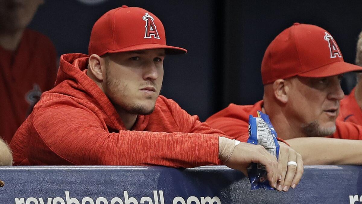 Mike Trout, who injured his right wrist Wednesday night, looks on from the dugout during the Angels'4-2 loss to Tampa Bay on Thursday.