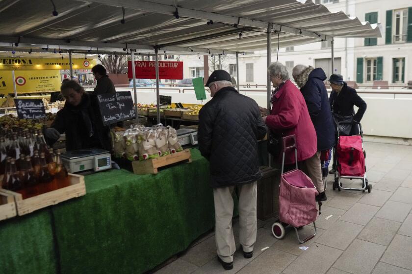 FILE - People shop at an open air market in Fontainebleau, south of Paris, France, on Feb. 2, 2024. The French government has announced a new rule that will require stores to tell customers when a product becomes smaller but its price stays the same or increases. This practice, known as shrinkflation, will need to be clearly communicated to shoppers under the rule that takes effect on July 1. The common but often-criticized practice has become an international phenomenon and buzzword. Consumer watchdogs have welcomed the new rule. (AP Photo/Thibault Camus, File)