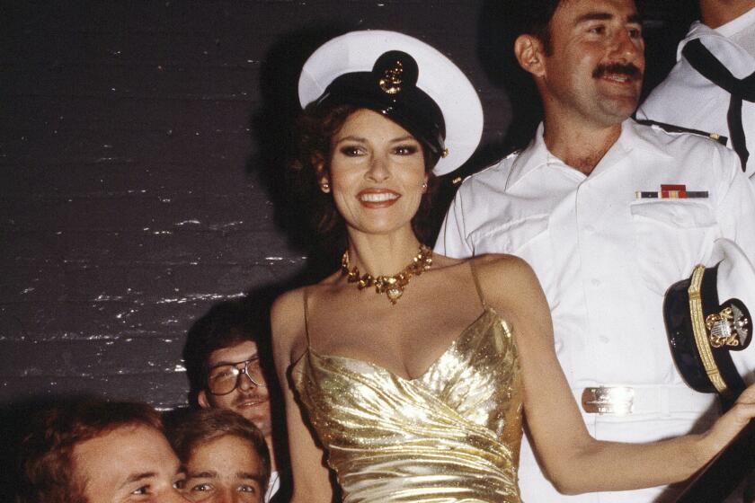 A woman in a tight-fitting gold gown wearing a sailor's hat surrounded by men in uniform
