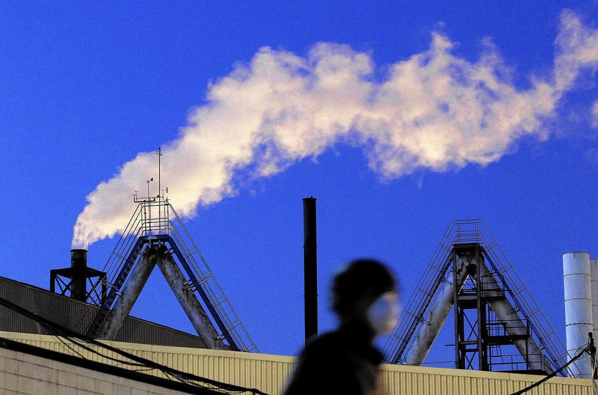 A protester wears a face mask at a demonstration outside Exide Technologies in Vernon last October. The battery recycler has again been found to have emitted more than the permitted level of lead, according to the South Coast Air Quality Management District.