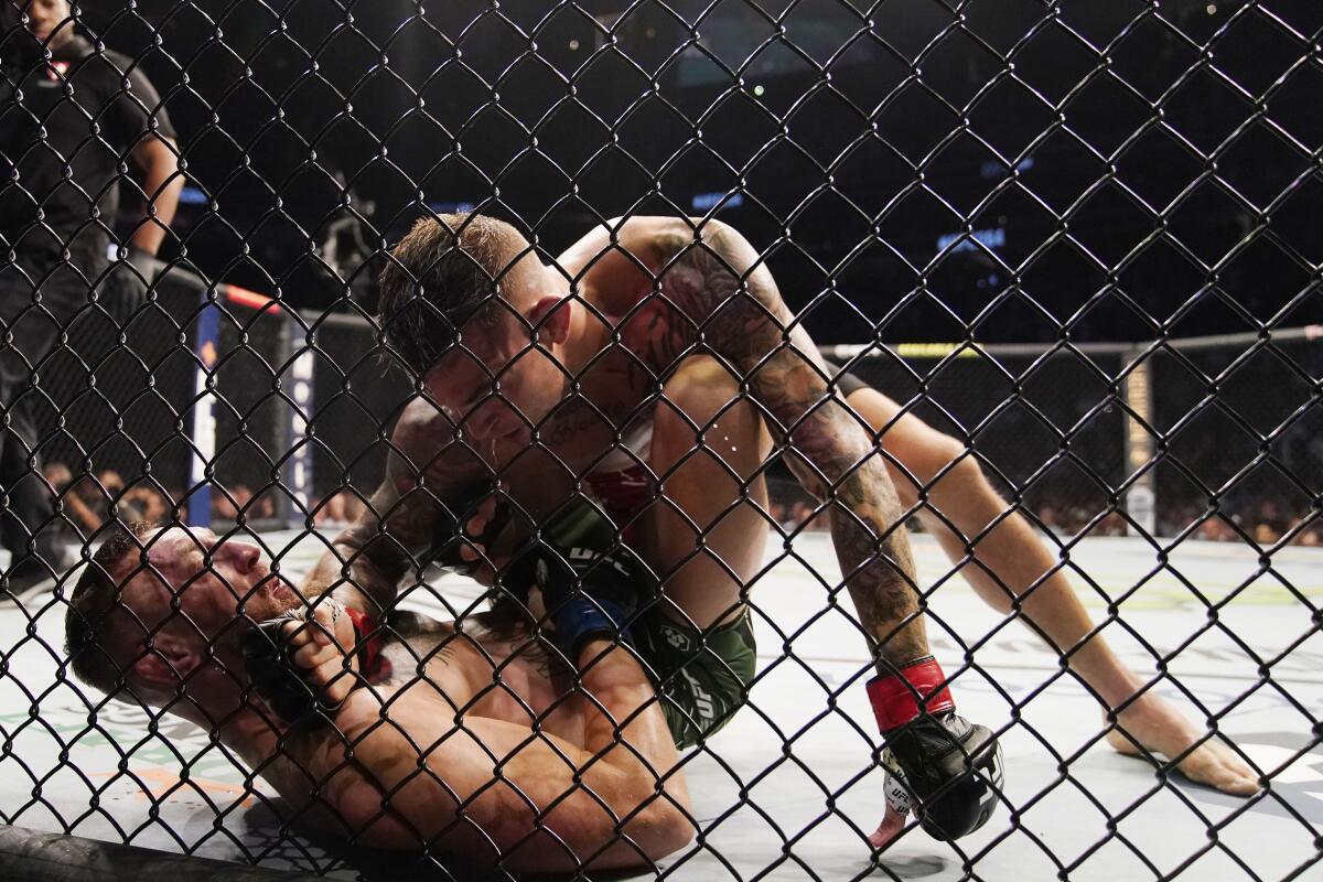 Dustin Poirier, top, wrestles Conor McGregor during a UFC 264 lightweight bout Saturday