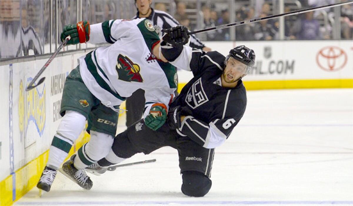 Jake Muzzin and Minnesota's Stephane Veilleux tumble to the ice during the Wild's 3-2 win Monday over the Kings.