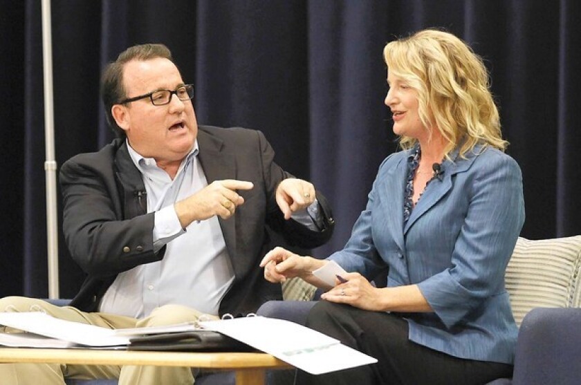 Costa Mesa Mayor Pro Tem Jim Righeimer, left, and Newport-Mesa Unified school board Trustee Katrina Foley have an animated discussion Monday night at the Neighborhood Community Center of the pros and cons of Costa Mesa having its own city charter.