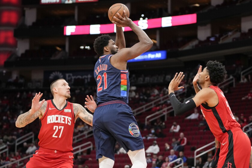 Philadelphia 76ers center Joel Embiid (21) shoots as Houston Rockets center Daniel Theis (27) and forward Christian Wood defend during the first half of an NBA basketball game, Monday, Jan. 10, 2022, in Houston. (AP Photo/Eric Christian Smith)